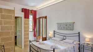 A bedroom with a bed, bedside tables, a round table, and a view of the outside. - B&B IreneMarchese - Gluten Free (Taviano)