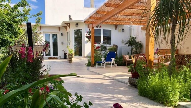 A covered outdoor area with a patio, potted plants, and a seating area with chairs. - B&B IreneMarchese - Gluten Free (Taviano)