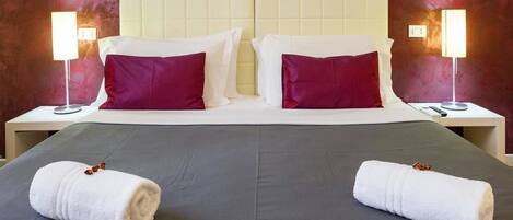 A hotel room with a large bed, two nightstands, and two bedside lamps.