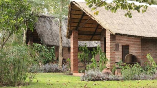 A rustic building with a thatched roof and brick walls, surrounded by greenery. - Barefoot Lodge and Safaris - Malawi - Campsite (Chitedze)