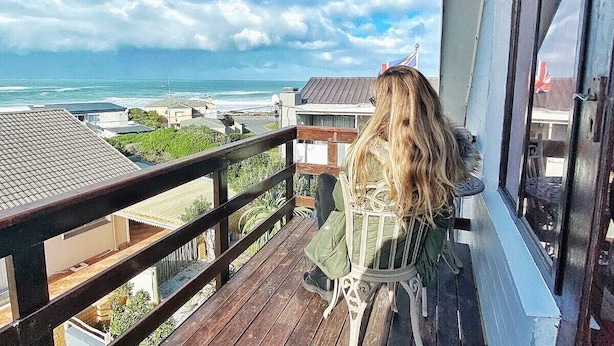 A balcony with a view of the ocean, a railing, and a chair. - The-Ark B & B (Pearly Beach)