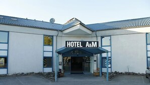 A building with a sign that reads "HOTEL A&M" at the entrance. - A&M Hotel Barsinghausen (Barsinghausen)