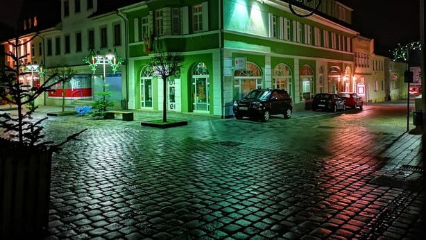 Un edificio histórico con fachada verde, ventanas arqueadas y un letrero que dice "Hotel Am Markt".