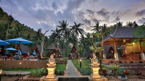 A resort with overwater bungalows, a pathway leading to the beach, and tropical vegetation. - Mahaloka Valley (Penida Island)
