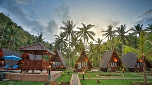 A resort with wooden cabins, a swimming pool, and a garden path. - Mahaloka Valley (Penida Island)