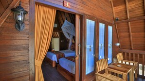 A wooden cabin room with two beds, a table, and chairs. - Mahaloka Valley (Penida Island)