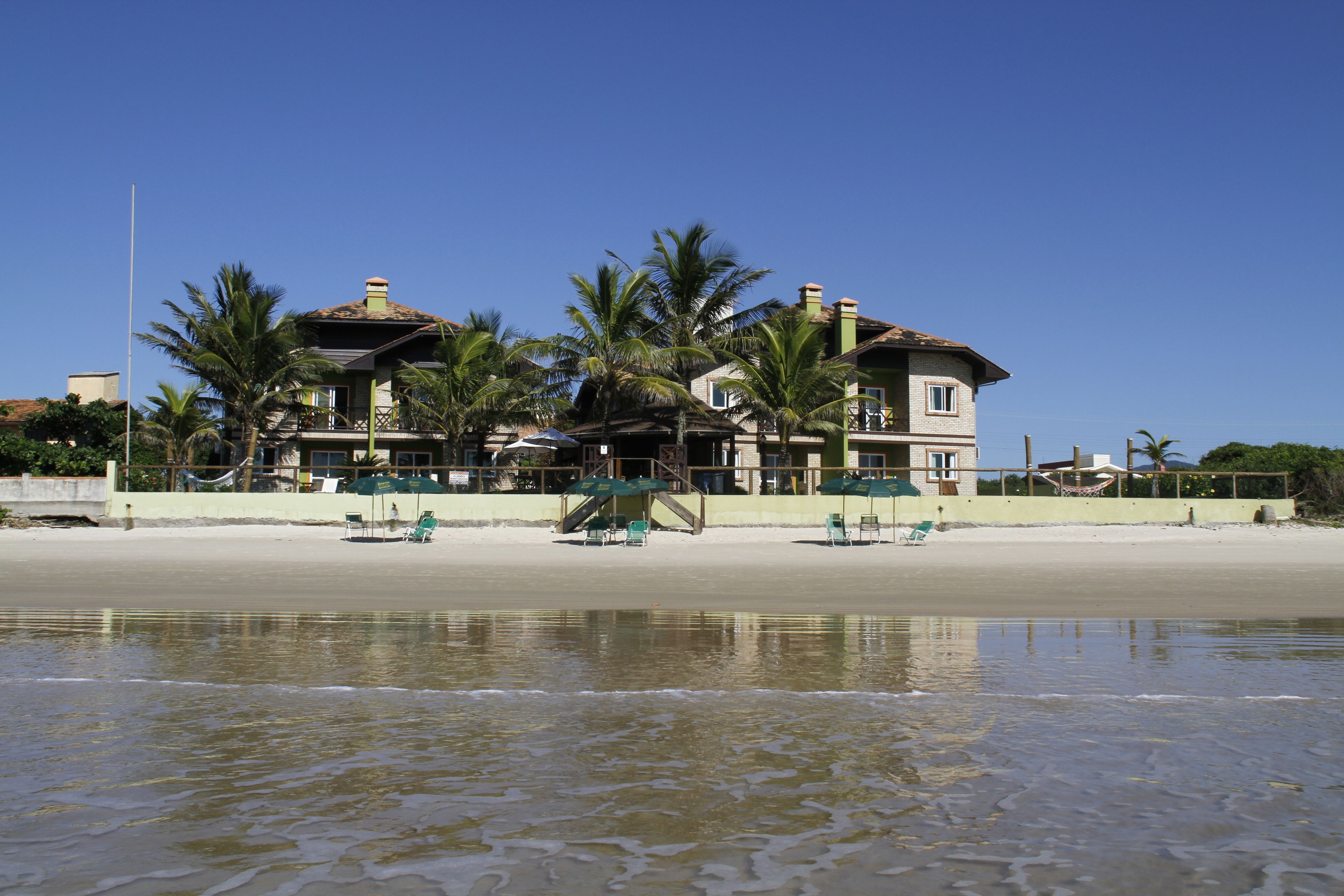 Na praia, areia branca, espreguiçadeiras, guarda-sóis 