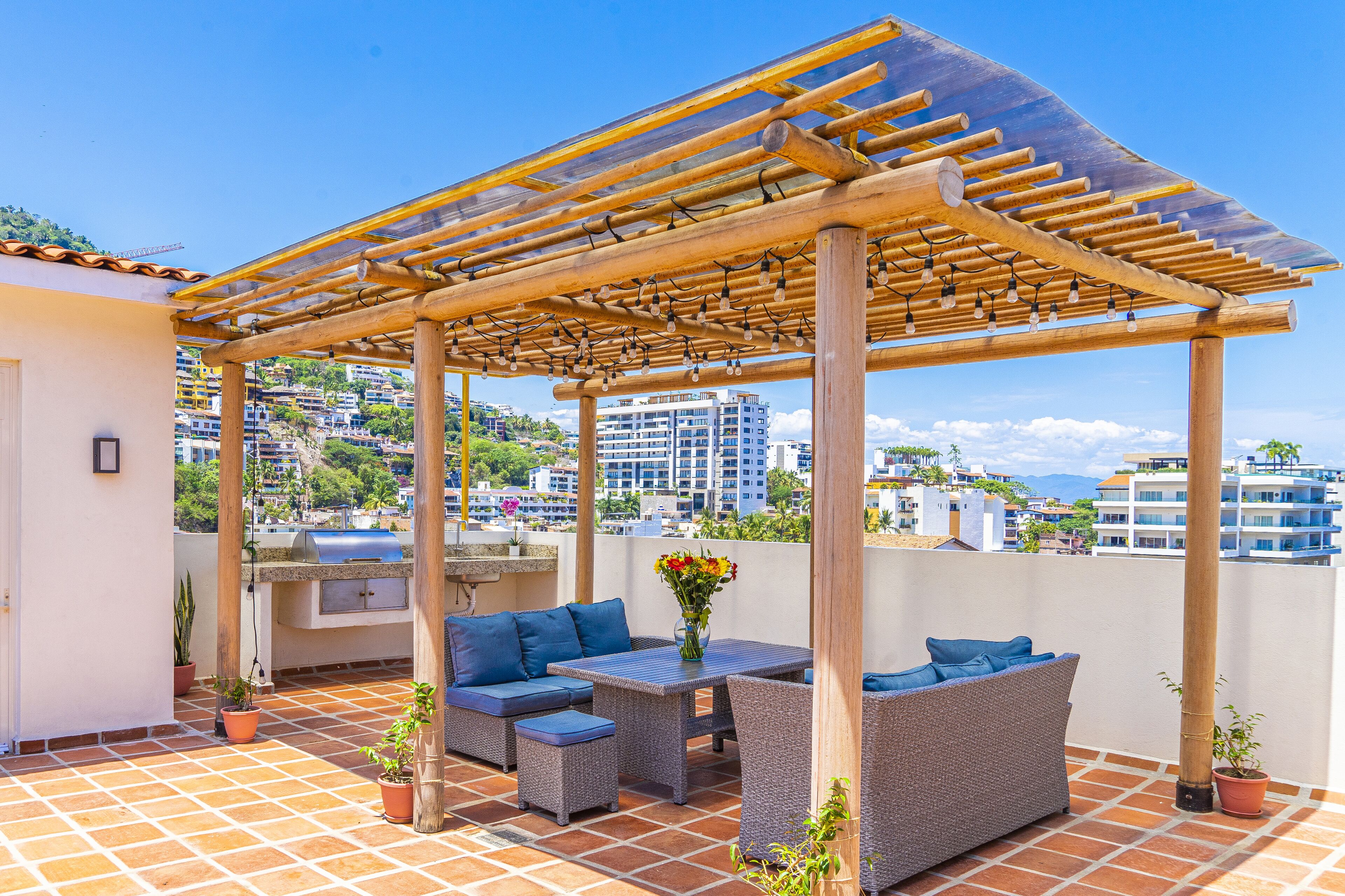 Une terrasse sur le toit agrémentée d’une pergola, de mobilier d’extérieur et d’un barbecue.