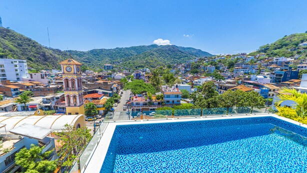 A swimming pool with a view of a town and a clock tower. - Tres Marias Luxury Suites - Adults Only (Puerto Vallarta)