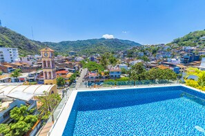 A swimming pool with a view of a town and a clock tower. - Tres Marias Luxury Suites - Adults Only (Puerto Vallarta)