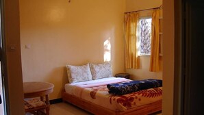 A bedroom with a bed, a chair, a small table, and a window with curtains. - Maison d'Hôtes au Jardin de Tamnougalt (Mezguita)