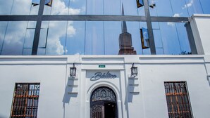 Un edificio con fachada blanca, un gran arco de entrada y un letrero que dice "Bálico".