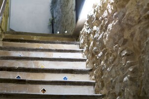 Una escalera con paredes de piedra y azulejos decorativos.