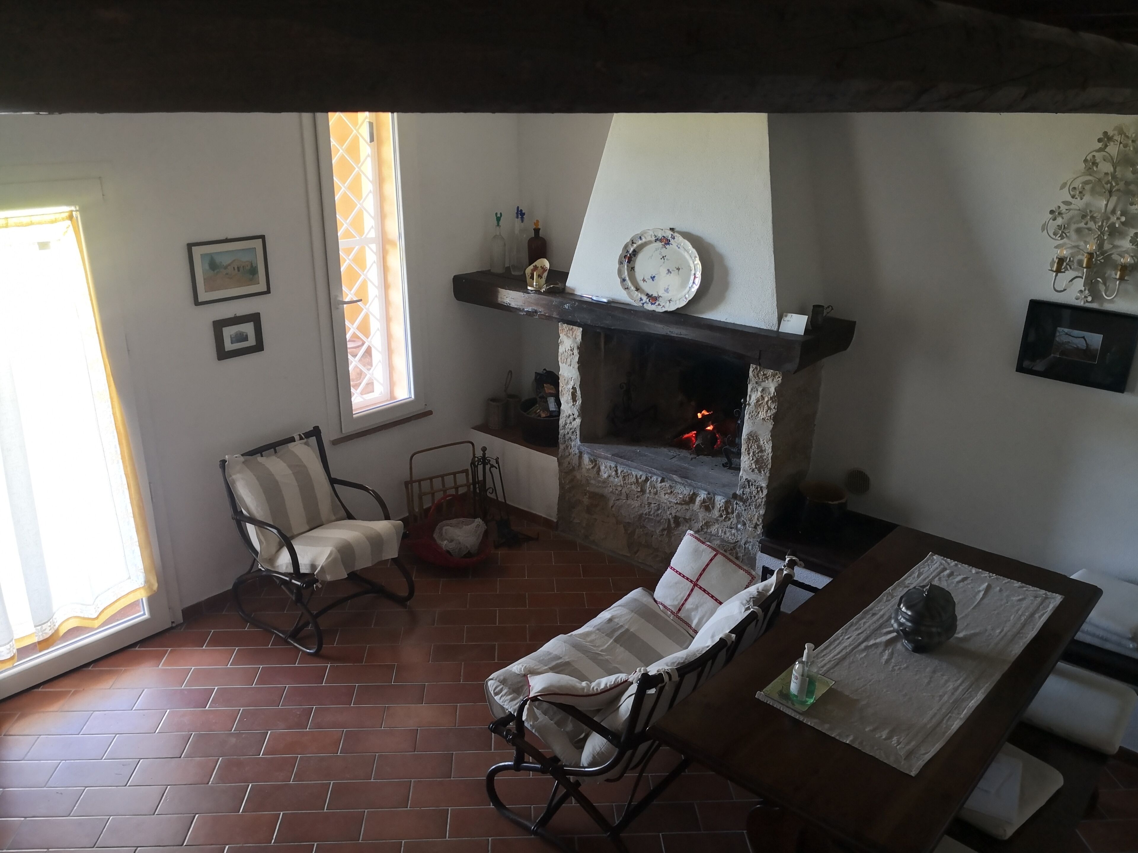 Una sala acogedora con chimenea, una mesa de comedor y dos mecedoras.