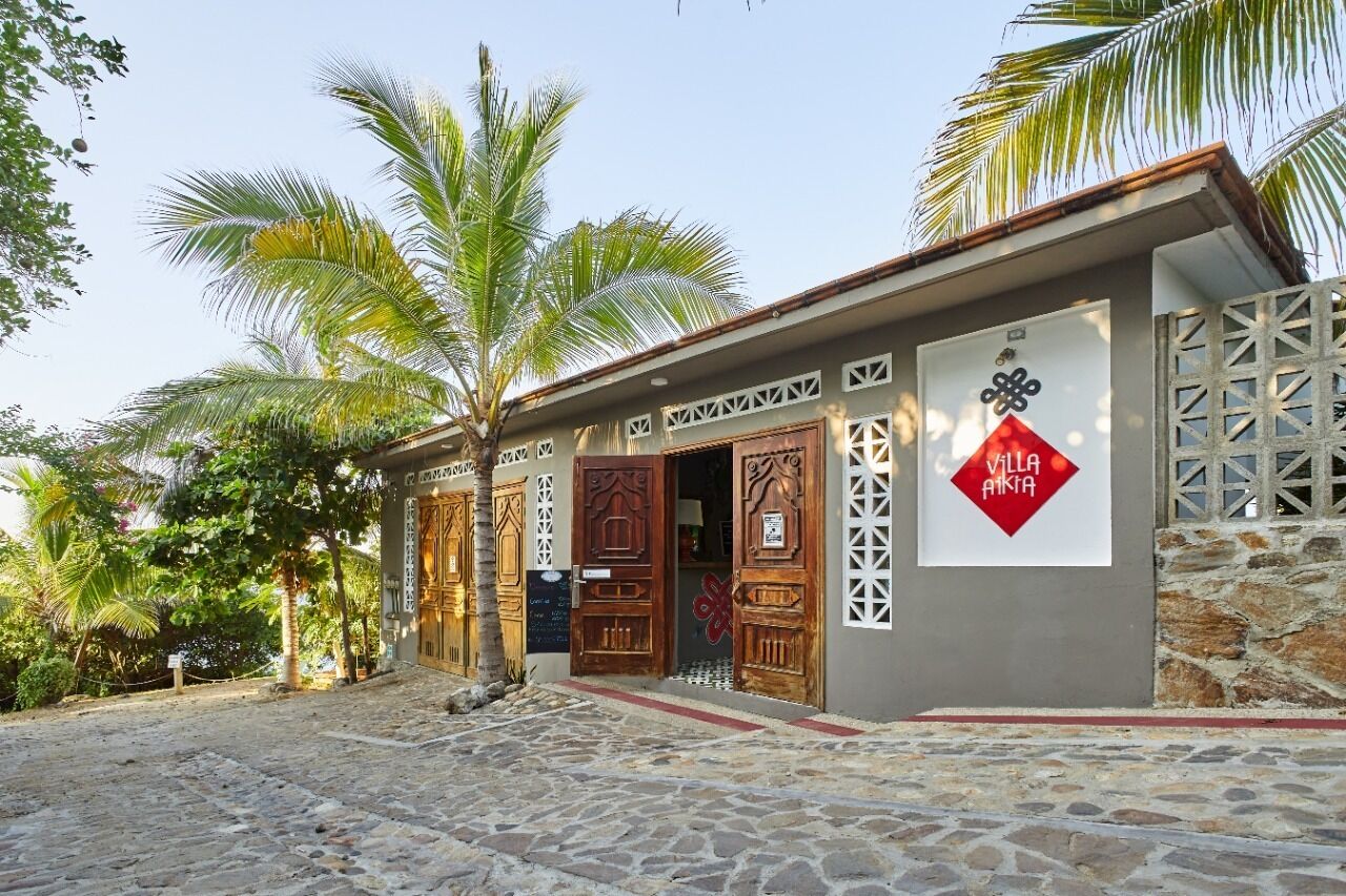 A building with ornate wooden doors and a sign reading "Villa Aikta".