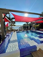 Una piscina al aire libre, sillones reclinables de piscina