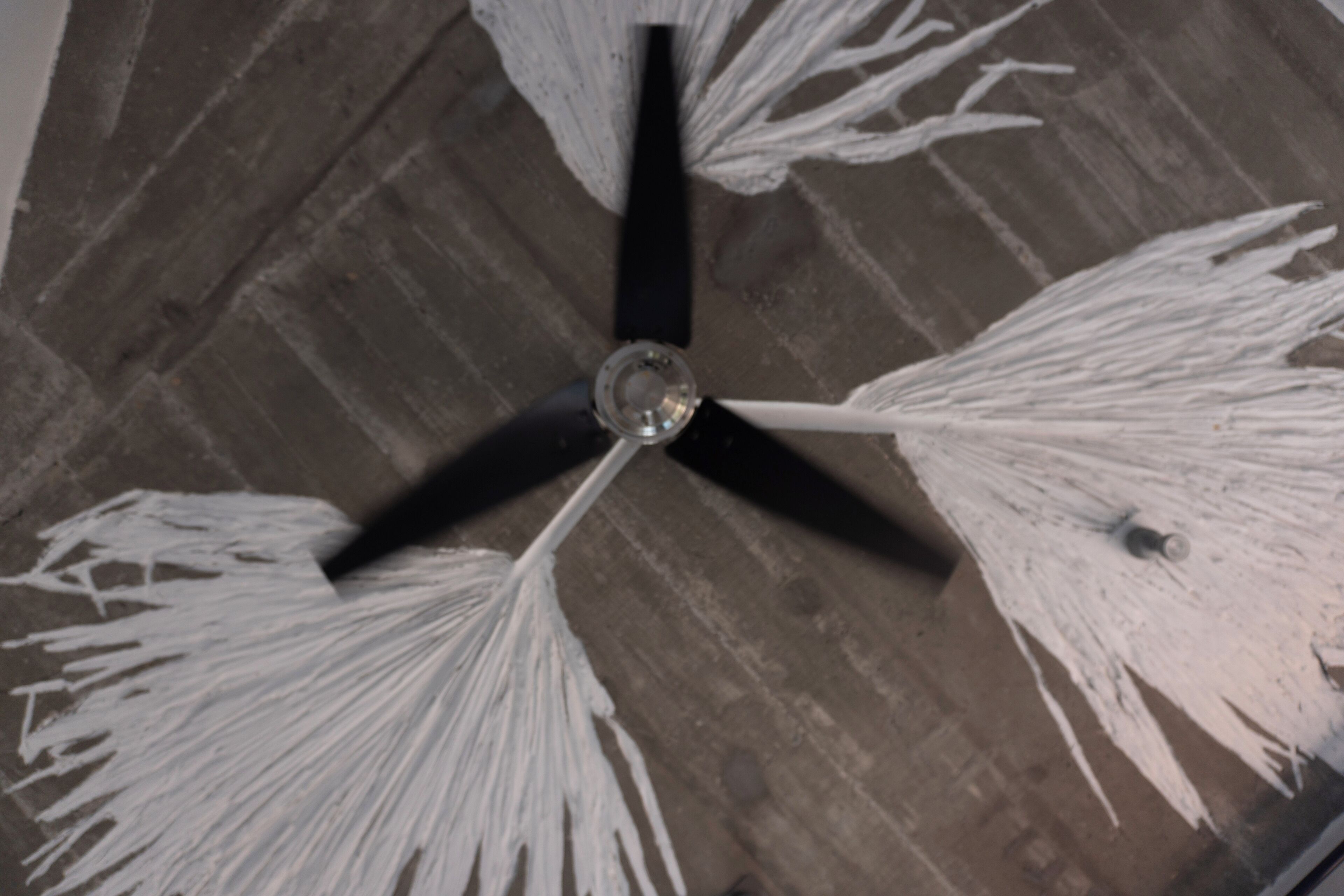 A ceiling fan with three blades and a central light fixture.