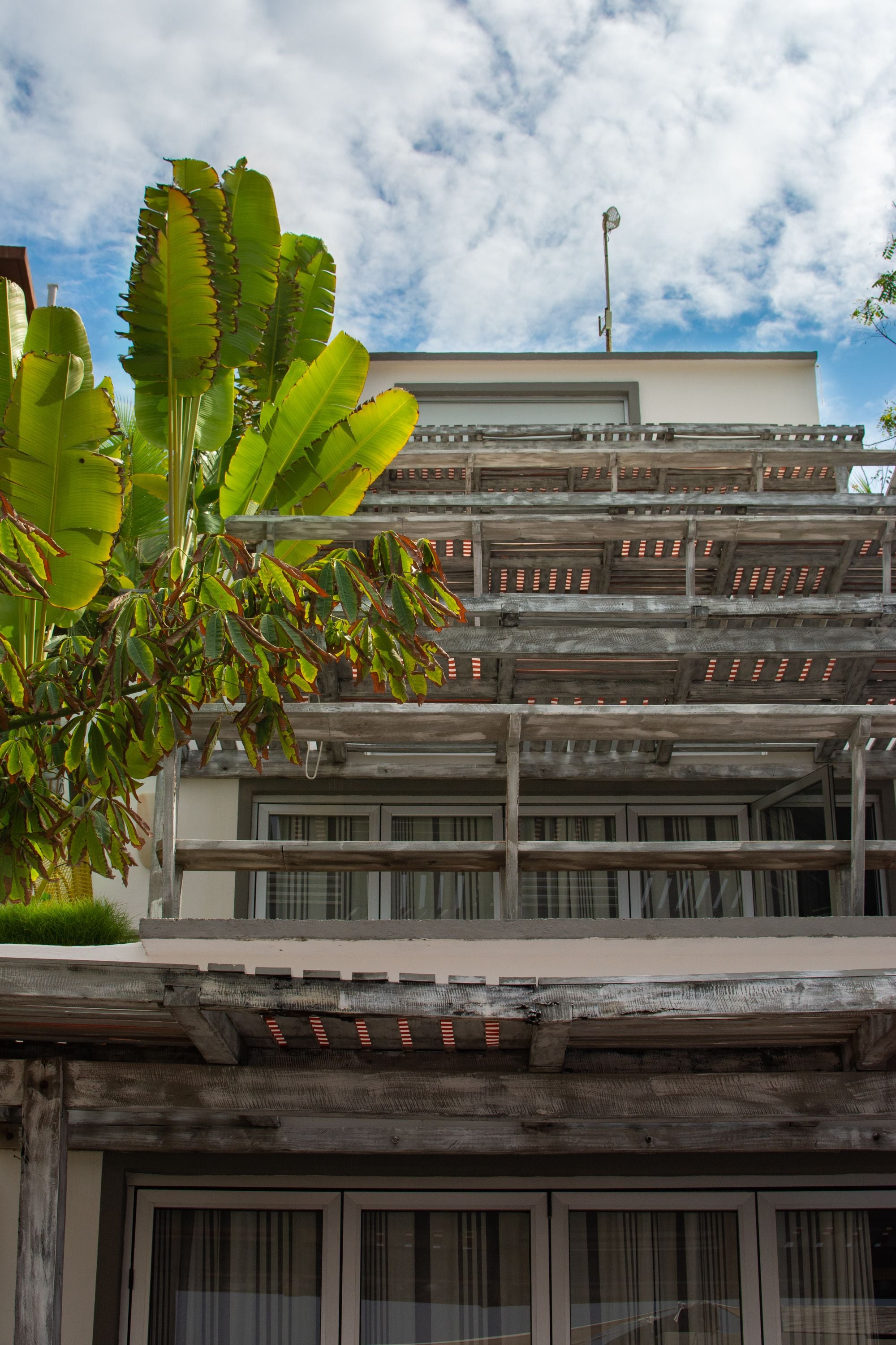 A multi-story building with a modern architectural design, featuring balconies and large windows.