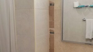A bathroom with a sink, mirror, and shower curtain. - Hotel San Antonio (Buenos Aires)