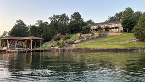 A lakeside property with a gazebo, a house with a balcony, and a landscaped garden. - Beautiful Balboa Waterfront! (Hot Springs Village)