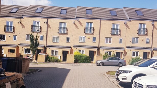 A residential building with multiple balconies, a paved driveway, and parked cars. - Lakeside Palace (Grays)