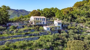A hillside property with multiple buildings, stone walls, and lush greenery. - S. Rocco dimora tra ulivi e M. (Zoagli)
