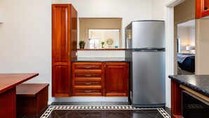 A kitchen with wooden cabinets, a stainless steel refrigerator, and a tiled floor. - Lighthouse Cozy 2BDR with CITY VIEWS (Middle Park)