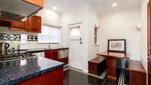A modern kitchen with granite countertops, wooden cabinets, a stainless steel stove, and a tiled backsplash. - Lighthouse Cozy 2BDR with CITY VIEWS (Middle Park)