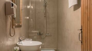 A modern bathroom with a large mirror, a sink, a toilet, and a shower.