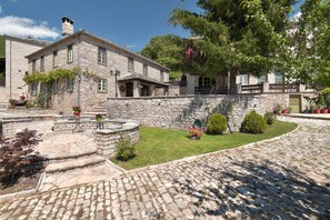 A stone building with a courtyard, stone steps, and potted plants. - Ameliko Zagori (Zagori)