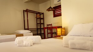 A hotel room with two beds, a wooden chair, a hanging chair, and a bedside table with a lamp. - Pousada Porto Azul (Caucaia)
