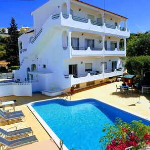 A multi-story white building with a swimming pool, outdoor seating, and a statue. - AAA Ana Albufeira Apartments (Albufeira)