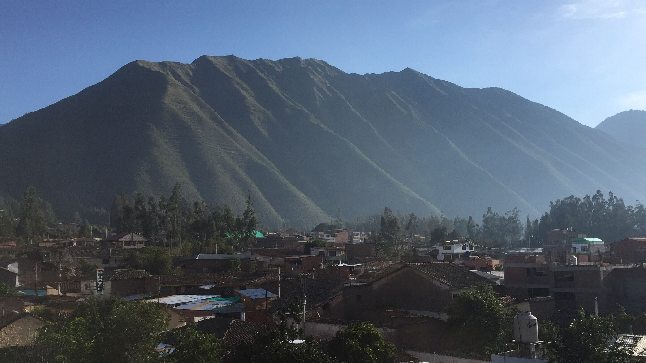 Un paysage montagneux avec un village au premier plan.