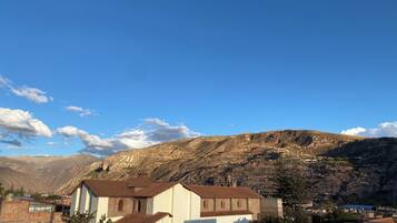 A mountainous landscape with a small village and a church with a bell tower.