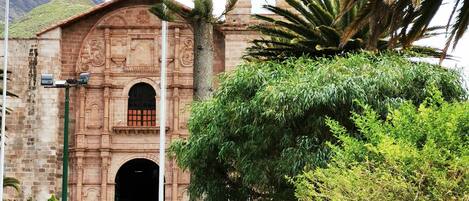 Un edificio histórico con una torre de campanas y una entrada abovedada.