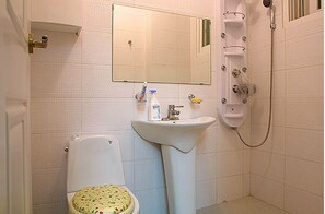 A bathroom with a toilet, sink, and shower.