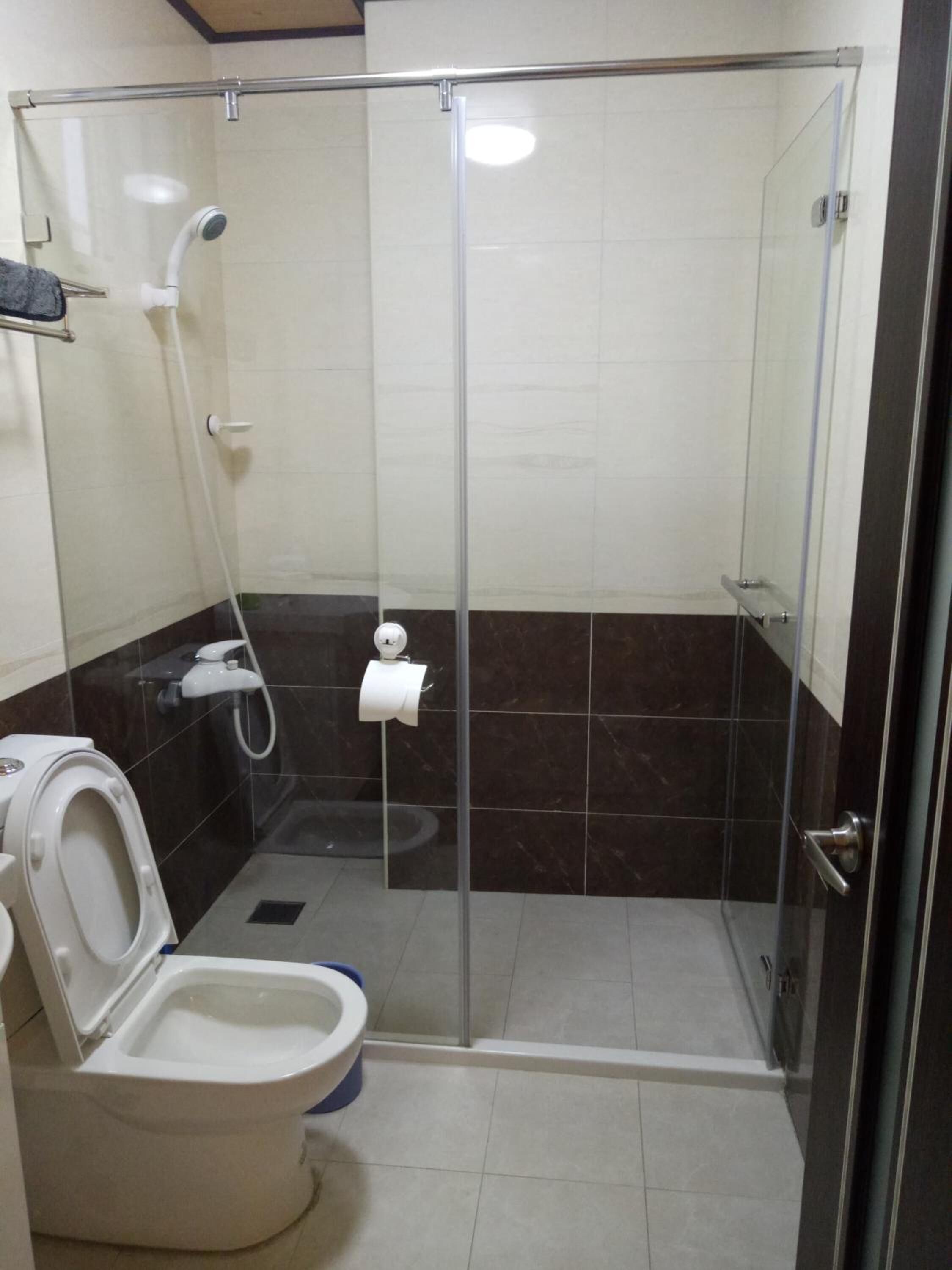 Un baño moderno con ducha envuelta en vidrio, inodoro y bidé.