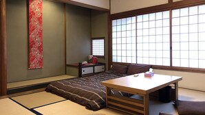 A traditional Japanese room with tatami flooring, a low wooden table, and a large shoji screen window. - Kinkaku Ryokan (Kyoto)