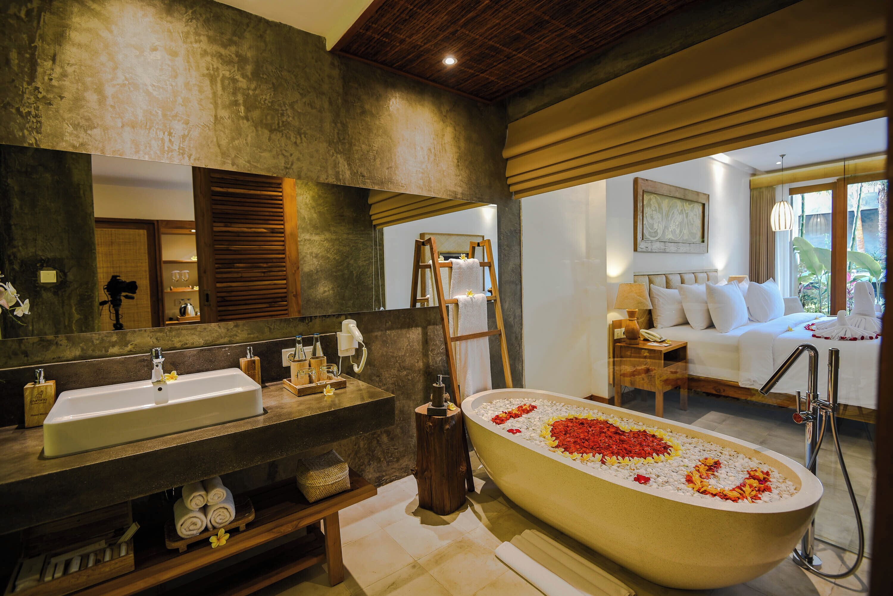 A modern bathroom with a large bathtub, a sink, and a mirror.
