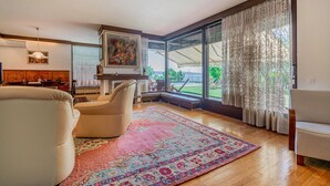 Un salon spacieux doté d’une grande fenêtre, d’une cheminée et d’un coin salon confortable.