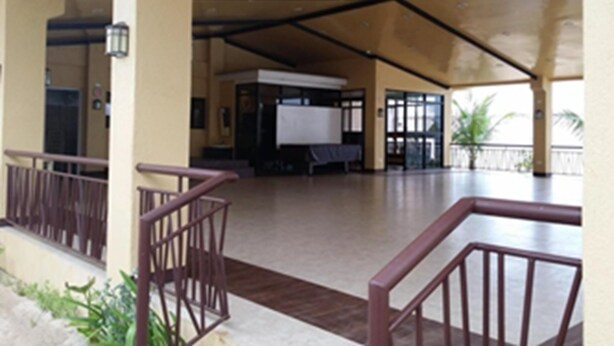 A spacious covered area with a wooden ceiling, a whiteboard, and a table. - Palm Seaside Inn and Beach Resort (Medellin)