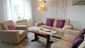 Een woonkamer met twee banken, een salontafel en een lamp.