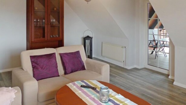 Een woonkamer met een bank, een gestreept tafeltje en een kast.