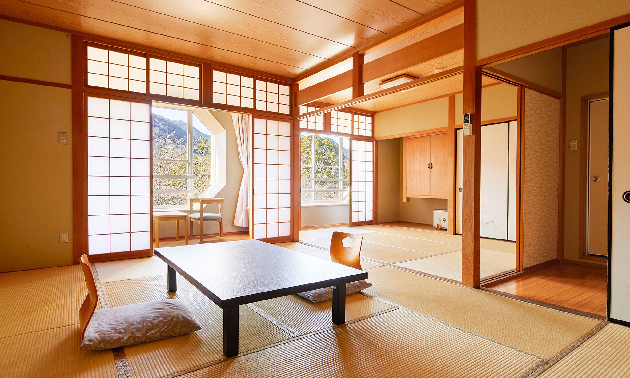 Una habitación japonesa tradicional con suelo de tatami, una mesa baja y puertas correderas.