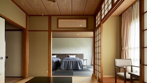 Ett traditionellt japanskt rum med tatamimattor på golvet, ett lågt trätak och skjutdörrar.