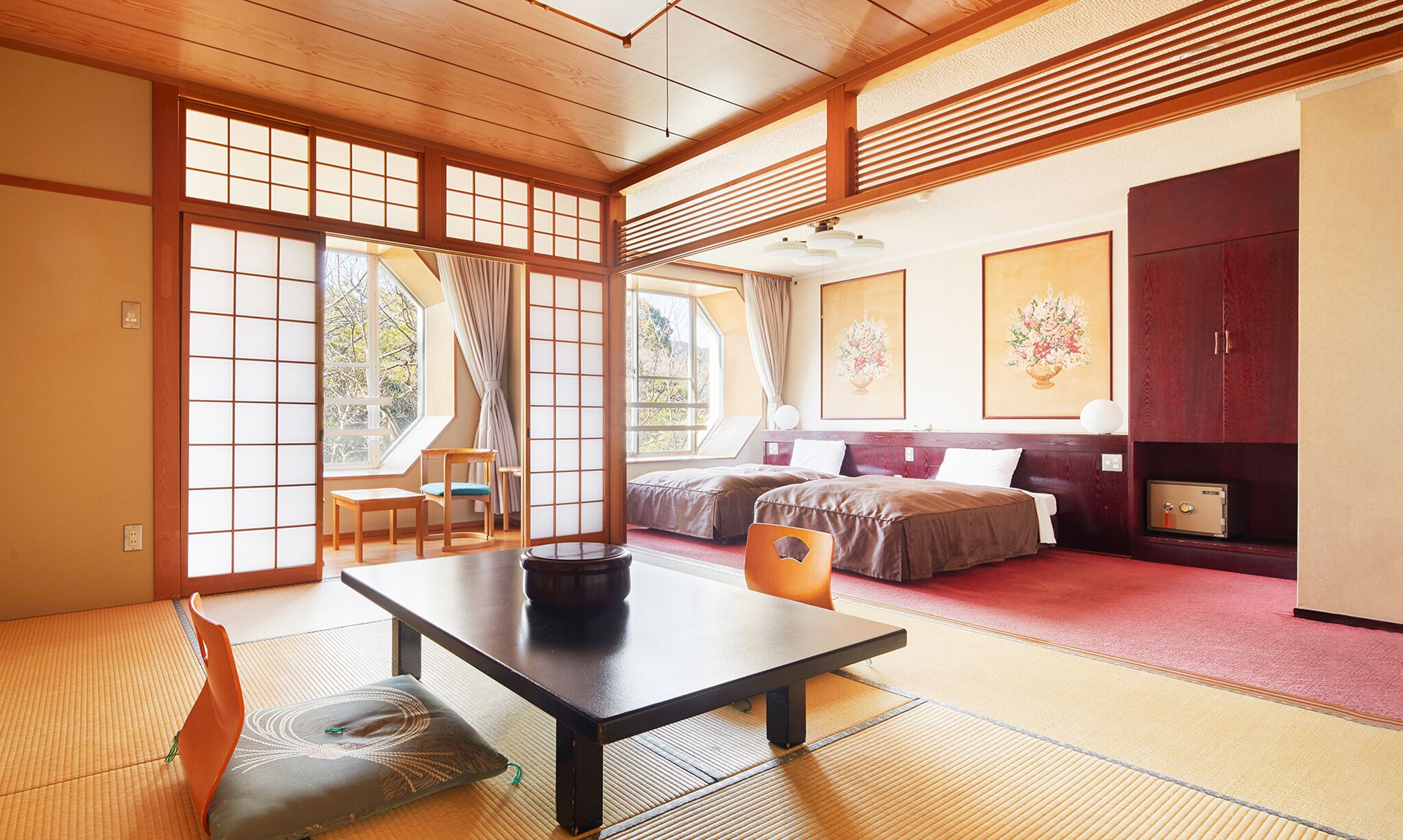 Una habitación tradicional japonesa con suelo de tatami, una mesa baja, un sofá y una cama.