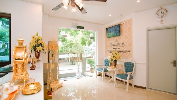 A hotel lobby with a reception desk, a ceiling fan, a clock, and a sign reading "King's Hotel". - King's Hotel Yen Hoa (Hanoi)