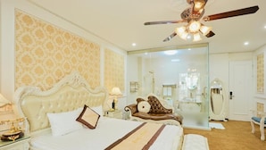 A spacious bedroom with a large bed, a ceiling fan, and a mirror. - King's Hotel Yen Hoa (Hanoi)