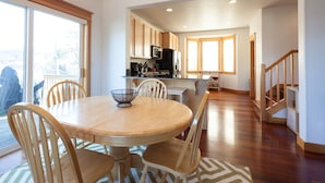 A spacious kitchen with wooden cabinets, a dining table with chairs, and a view through large windows. - Private Reserve 3 Bedroom Townhouse by RedAwning (Hood River)
