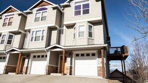 A multi-story residential building with a symmetrical facade, multiple garage doors, and a balcony on the right side. - Private Reserve 3 Bedroom Townhouse by RedAwning (Hood River)